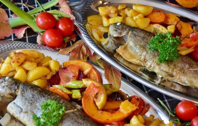 Plat de poisson cuisiné avc des pommes de terre, des aromates et des fruits